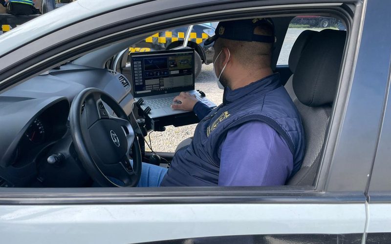 Agente operando el sistema de lectura de placas en patrulla